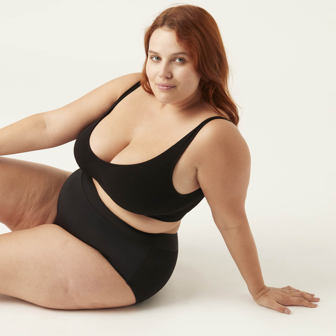 Large woman sitting wearing No. 1 Modibodi Menstruation Swim Bikini High Waist Bottoms 