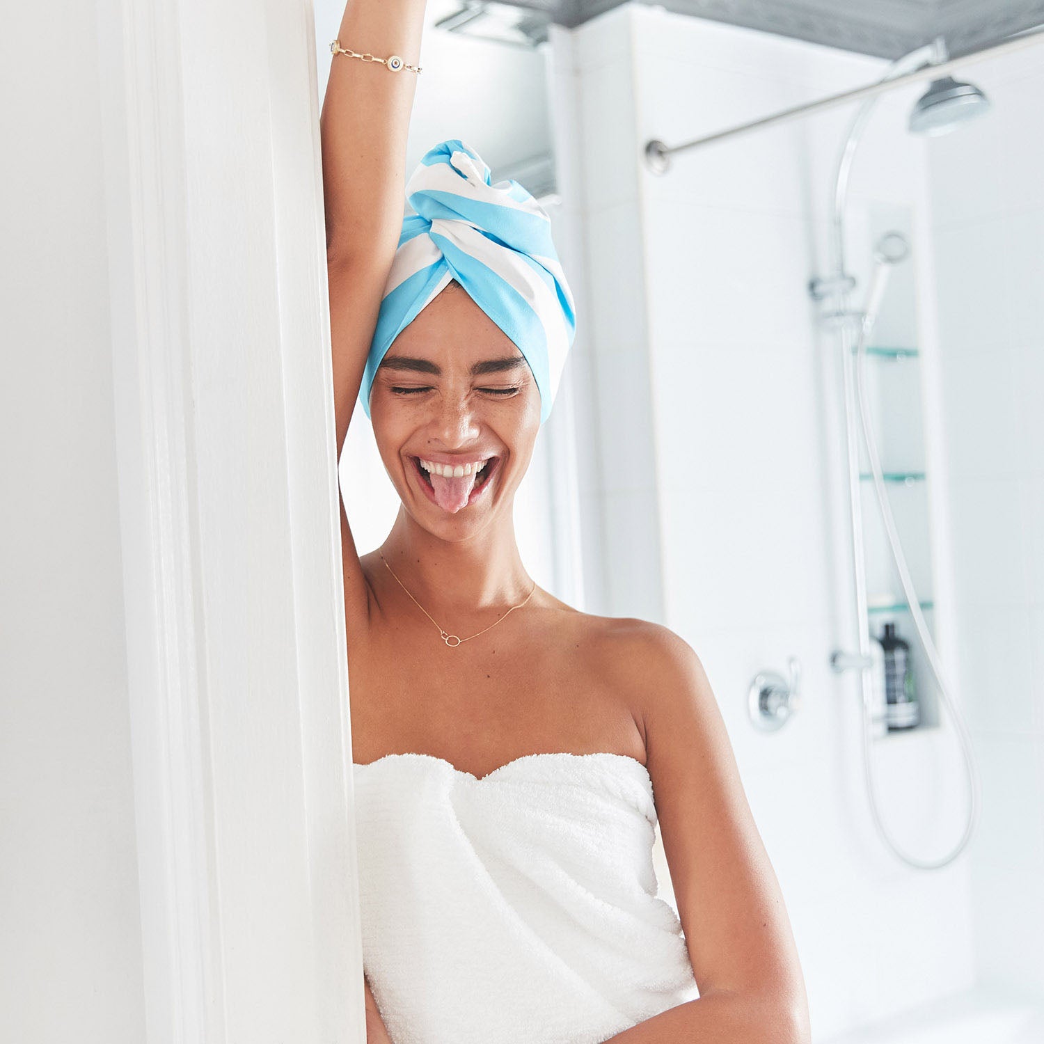Girl standing smiling wearing hair wrap and towel 