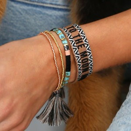 4 bracelets stacked on a wrist. 